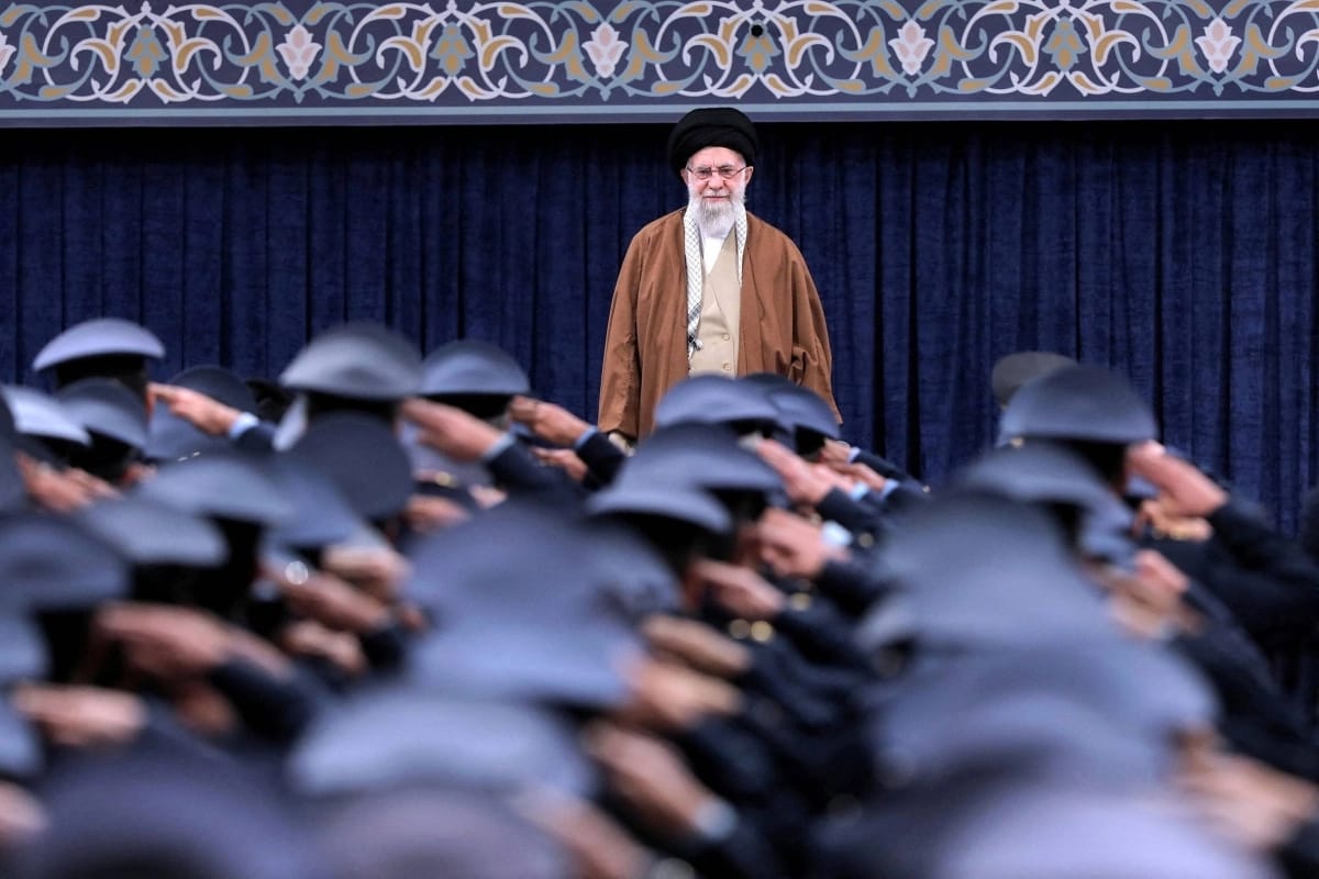 Iranian Supreme Leader Ali Khamenei listens to the national anthem as Air Force officers salute during a meeting in Tehran in February